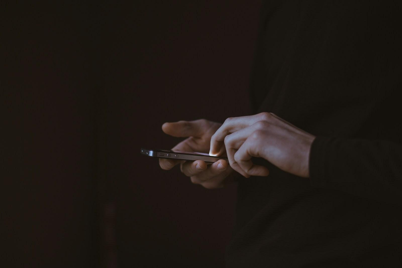 Person with a smartphone for an online donation.