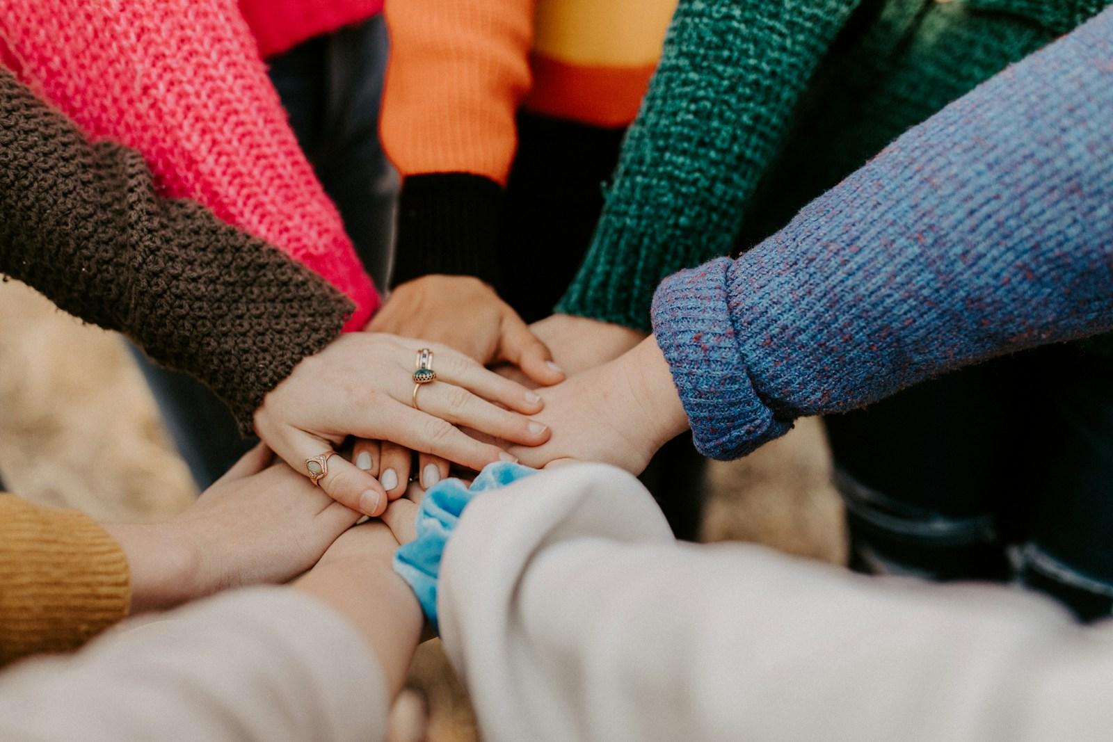 People stacking their hands for a shared charity campaign